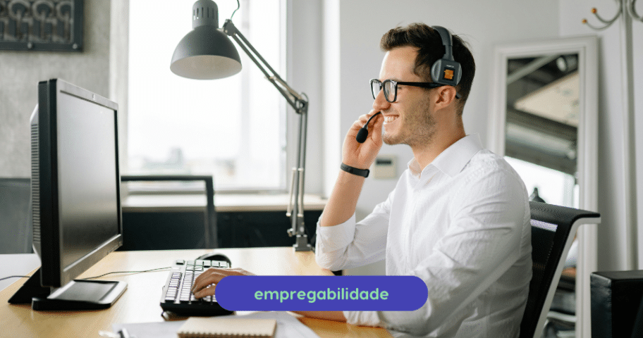 Descrição de Imagem: Profissional de tecnologia em ambiente de escritório usando fones de ouvido e computador, representando empregabilidade e oportunidades de carreira na tecnologia.