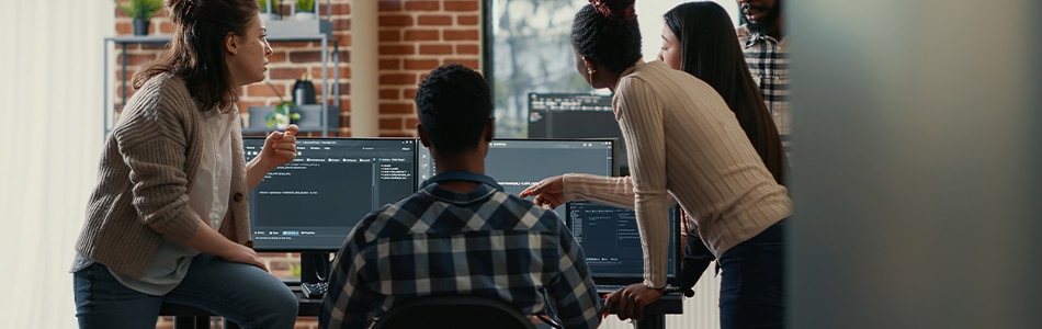 Descrição da Imagem: Um grupo de pessoas trabalhando em computadores em um escritório.