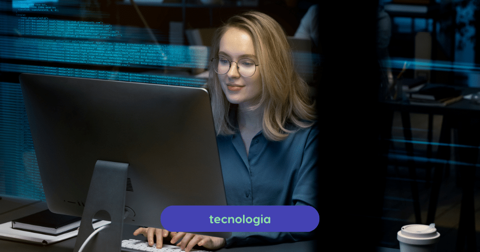Descrição de Imagem: Uma mulher loira de óculos está trabalhando em um computador com banco de dados, com foco em tecnologia.