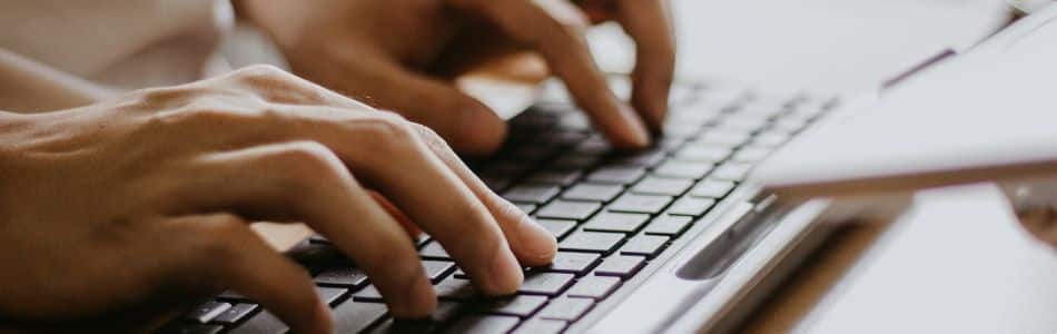 Descrição de Imagem: Pessoa digitando em um teclado de computador.
