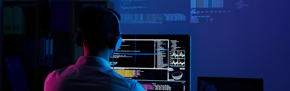 Descrição de Imagem: Uma pessoa sentada e trabalhando em uma mesa olhando para a tela de um computador com DevSecOps.