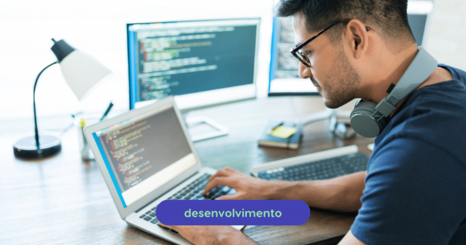 Um homem com óculos e fones de ouvido trabalha em um laptop em um escritório. As telas de computador exibindo código são visíveis em segundo plano. A palavra “desenvolvimento” aparece em uma caixa azul na parte inferior da imagem, destacando as diferenças entre o serviço web e as funcionalidades da API.